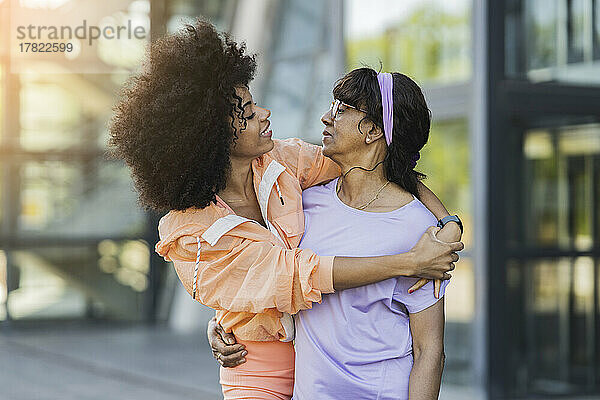 Afro-Frau umarmt ältere Frau