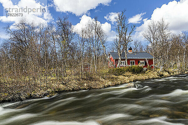 Schweden  Jämtland County  abgelegenes Haus am Flussufer im Herbst