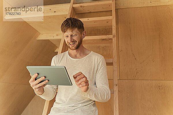 Man setting up a smart home unit with digital tablet in eco home