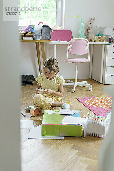 Girl doing craftwork sitting at home