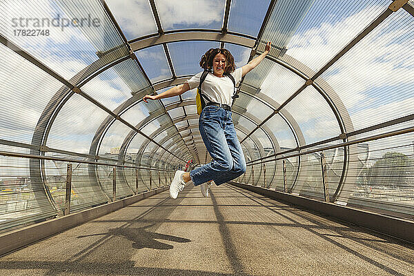 Glückliches Teenager-Mädchen springt auf Brücke am Bahnhof Elbbrücken  Deutschland