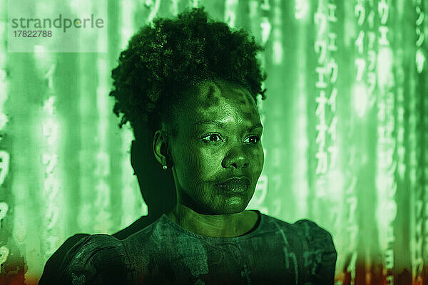 Digitaler Code fällt auf Frau mit Afro-Frisur vor Wand