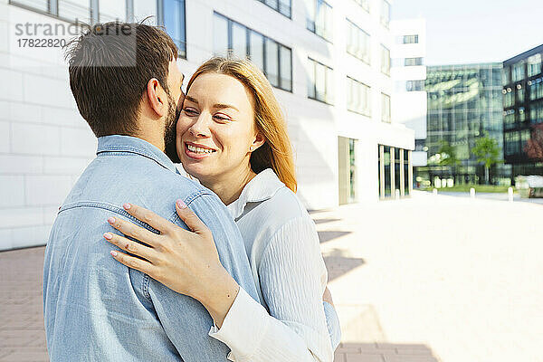 Glücklicher Mann und Frau umarmen sich an einem sonnigen Tag