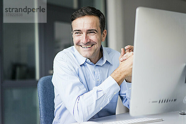 Smiling businessman sitting at desk in office