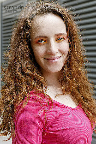 Glückliche schöne rothaarige Frau mit orangefarbenem Lidschatten-Make-up