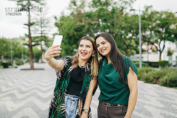Glückliche Freunde  die im Park ein Selfie mit dem Smartphone machen