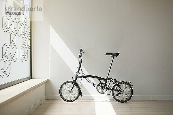 Fahrrad lehnt an weißer Wand im Yogastudio