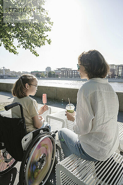 Mutter und Tochter sitzen an einem sonnigen Tag im Park