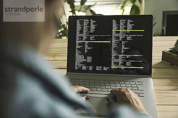 Computerprogrammierer nutzt Laptop und arbeitet im Heimbüro