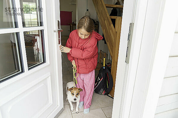 Girl with dog at entrance of house