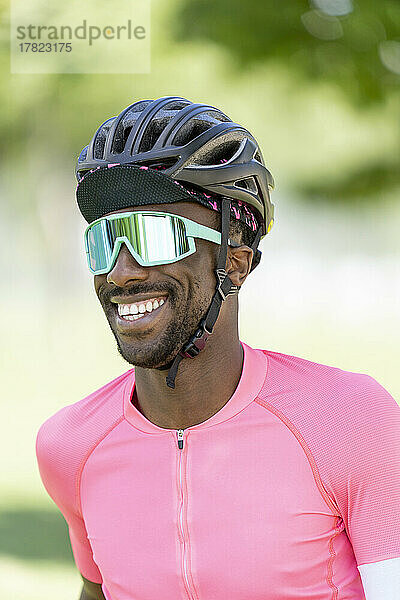 Smiling man wearing cycling helmet and sunglasses