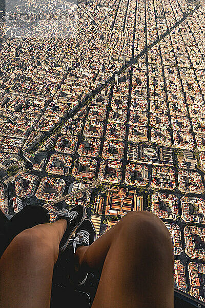 Spain  Catalonia  Barcelona  Personal perspective of young woman riding helicopter over densely populated residential district