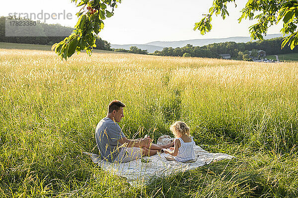 Vater und Tochter genießen Picknick auf dem Feld