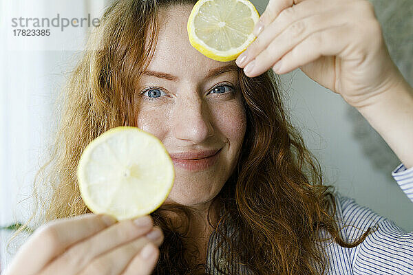 Lächelnde Frau mit Zitronenscheiben