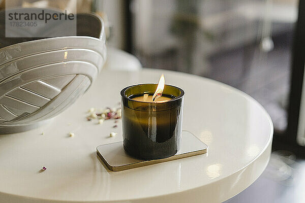 Burning scented candle on table at home