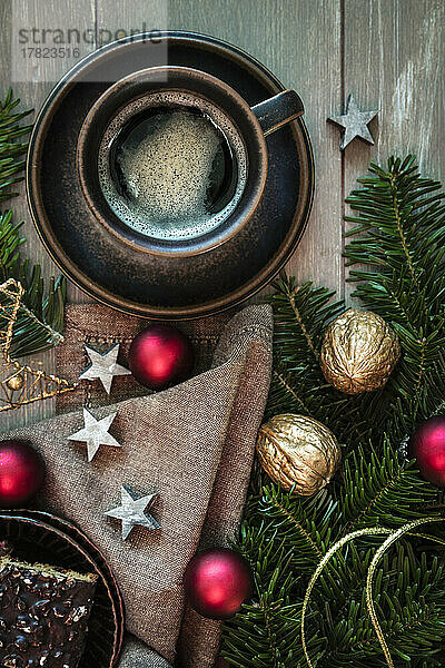 Studioaufnahme einer Tasse Kaffee  Zweigen  Geschirrtuch  Weihnachtsschmuck und Lebkuchen