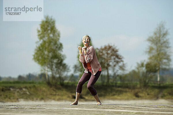Fröhliche Frau tanzt an einem sonnigen Tag