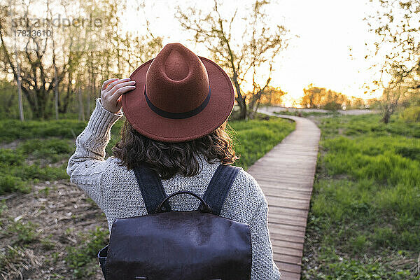 Frau mit Hut geht im Park spazieren