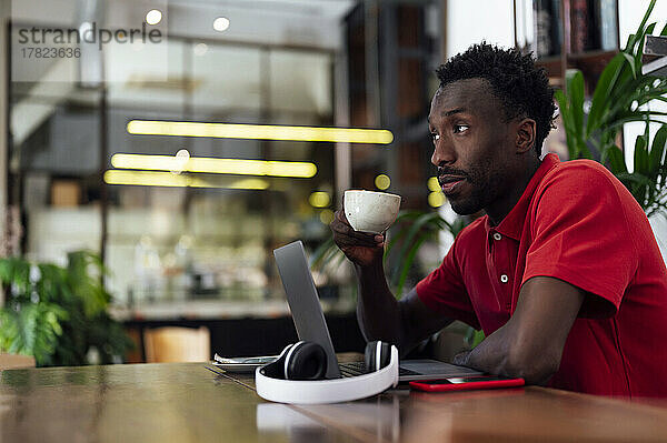 Mann mit Kaffeetasse sitzt im Café