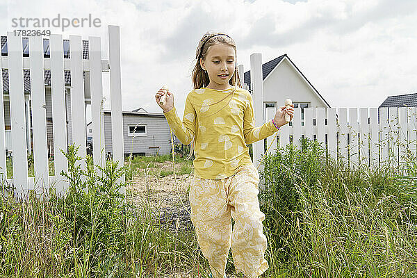 Mädchen spielt mit Springseil im Hinterhof