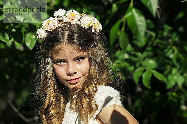 Smiling girl wearing flower crown in forest