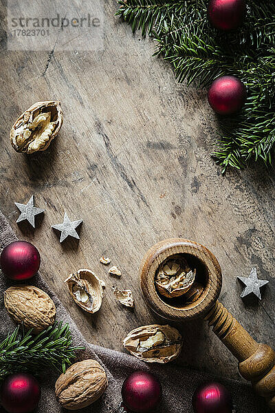 Studio shot of cutting board  twigs  Christmas ornaments  walnuts and simple nutcracker