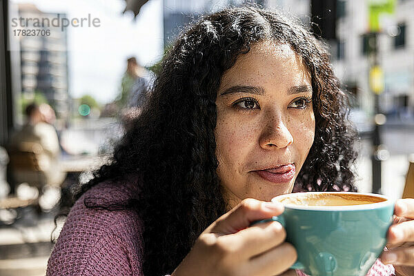 Junge Frau genießt Kaffee an einem sonnigen Tag