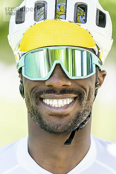 Glücklicher Mann mit Fahrradhelm und Sonnenbrille