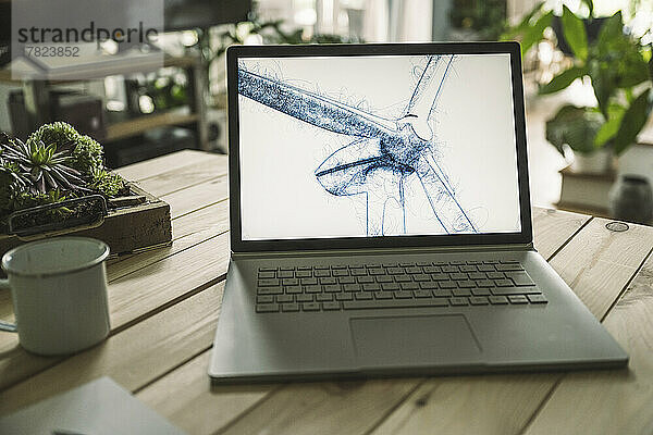 Skizze einer Windkraftanlage auf dem Bildschirm eines Laptops im Heimbüro