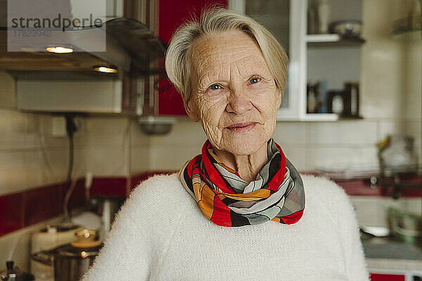 Lächelnde ältere Frau mit kurzen weißen Haaren in der Küche