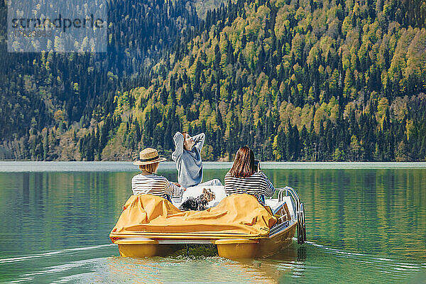 Frauen fahren an einem sonnigen Tag mit dem Tretboot auf dem Ritsa-See