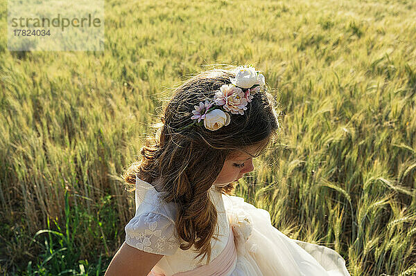 Girl wearing communion dress in wheat field