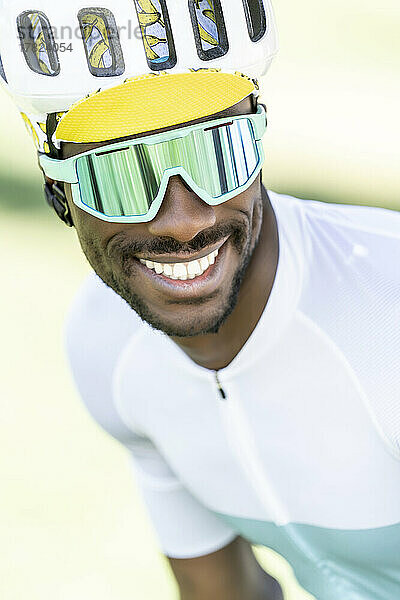 Happy cyclist wearing cycling helmet and sunglasses
