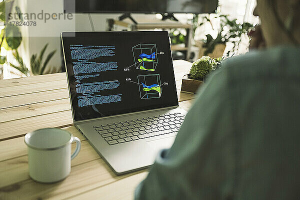 Freiberuflicher Programmierer mit Laptop und Kaffeetasse im Heimbüro