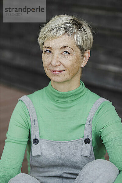 Lächelnde reife Frau mit kurzen blonden Haaren