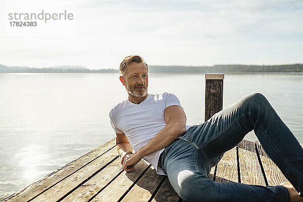 Reifer Mann entspannt sich am Pier am See