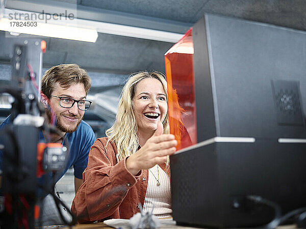 Zufriedene Techniker schauen sich den SLA-Drucker in der Werkstatt an