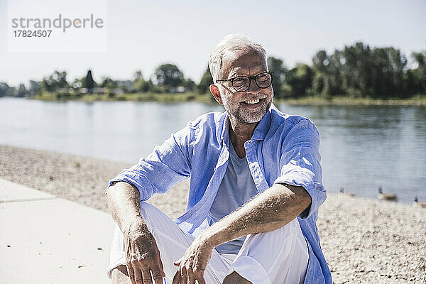 Glücklicher älterer Mann am Flussufer