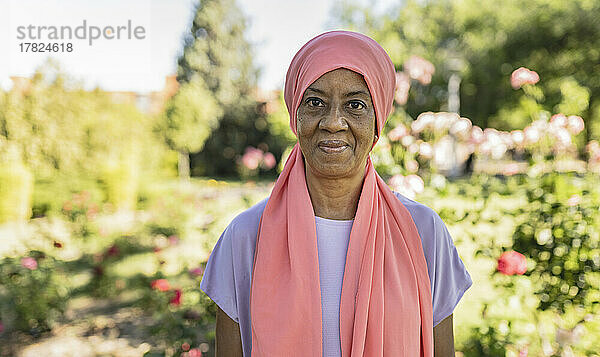 Lächelnde ältere Frau mit Kopftuch im Park
