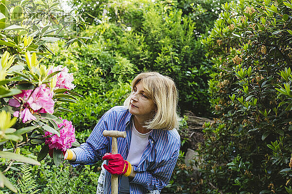 Frau untersucht Blumen im Garten