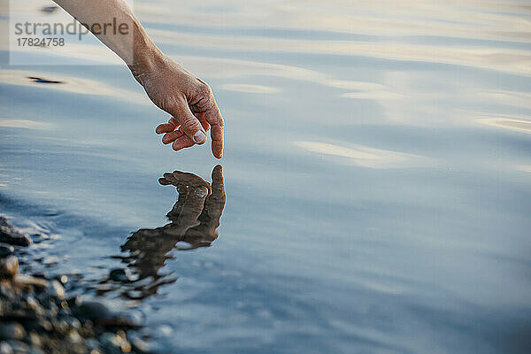 Hand of man touching water