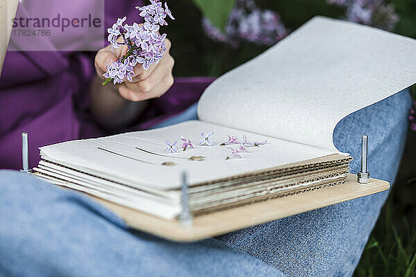 Frau mit Buch und lila Blumen