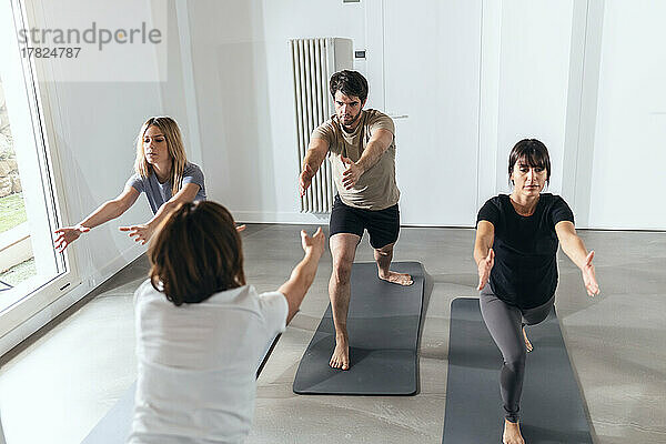 Männer und Frauen praktizieren Yoga im Übungskurs
