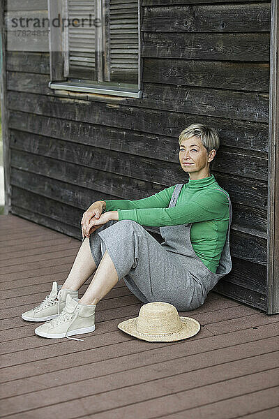 Nachdenkliche Frau sitzt auf der Veranda