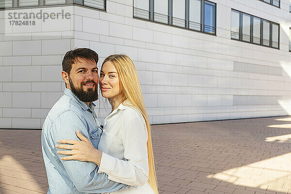 Glücklicher Mann und Frau stehen vor dem Gebäude