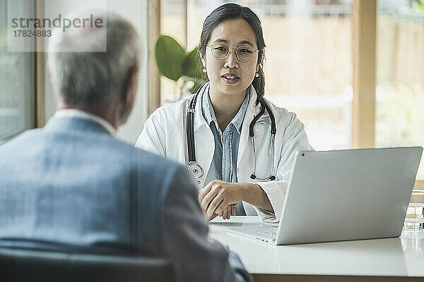 Ärztin mit Brille diskutiert mit Patientin