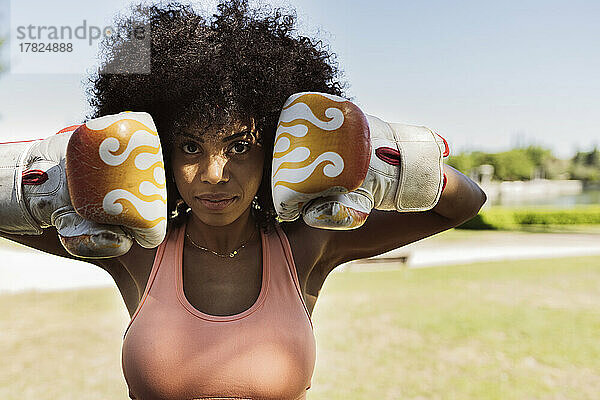 Afro-Frau mit Boxhandschuhen im Park