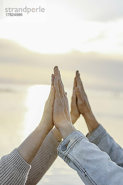 Girlfriend and boyfriend touching hands at sunset