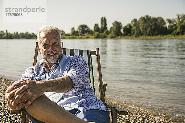 Lächelnder älterer Mann am Flussufer