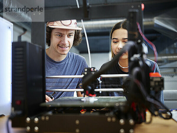 Ingenieur und Kollege bedienen 3D-Drucker in der Werkstatt
